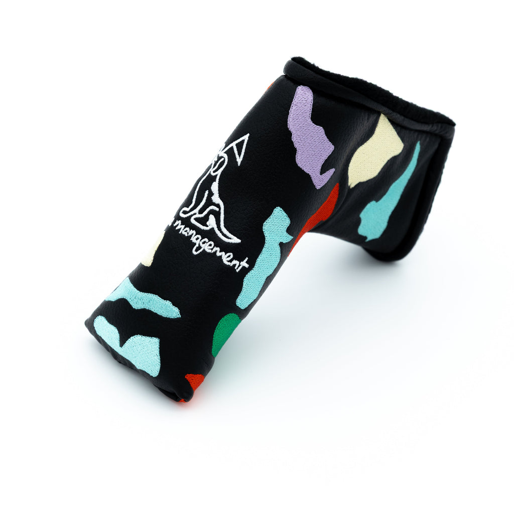 A black golf putter headcover featuring a colorful abstract pattern with a white stylized logo and the words 'course management' printed on the side.