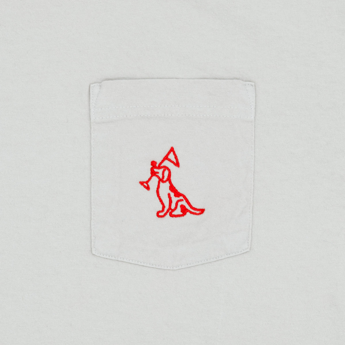 Close-up of a white pocket t-shirt featuring a red embroidered logo of a dog on the pocket.