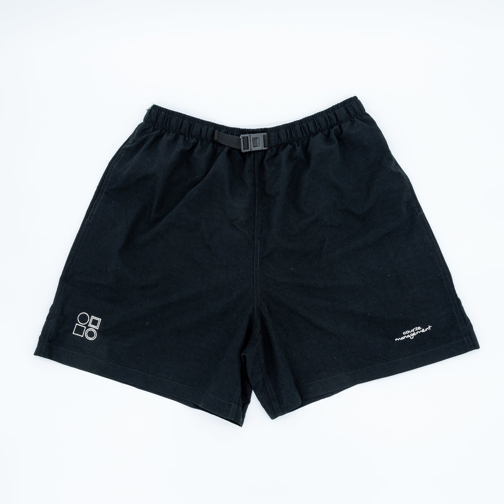 Black athletic shorts with an elastic waistband and a small white logo on the left leg, laid flat on a white background.