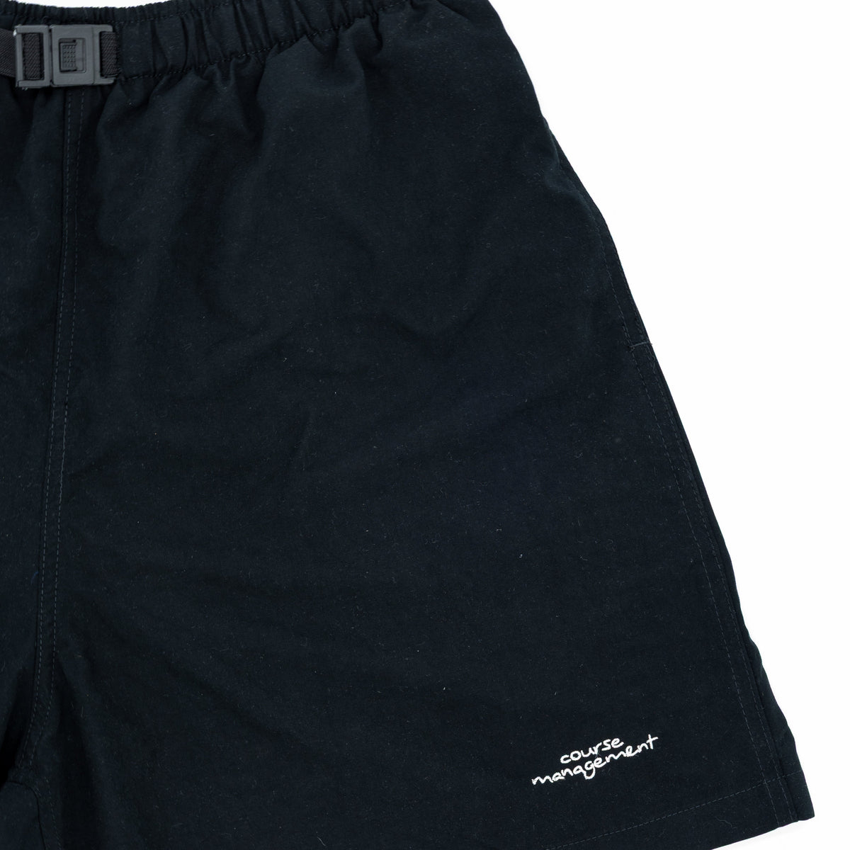 Black athletic shorts with an elastic waistband and a small white embroidered logo on the lower left leg, shown against a plain white background.