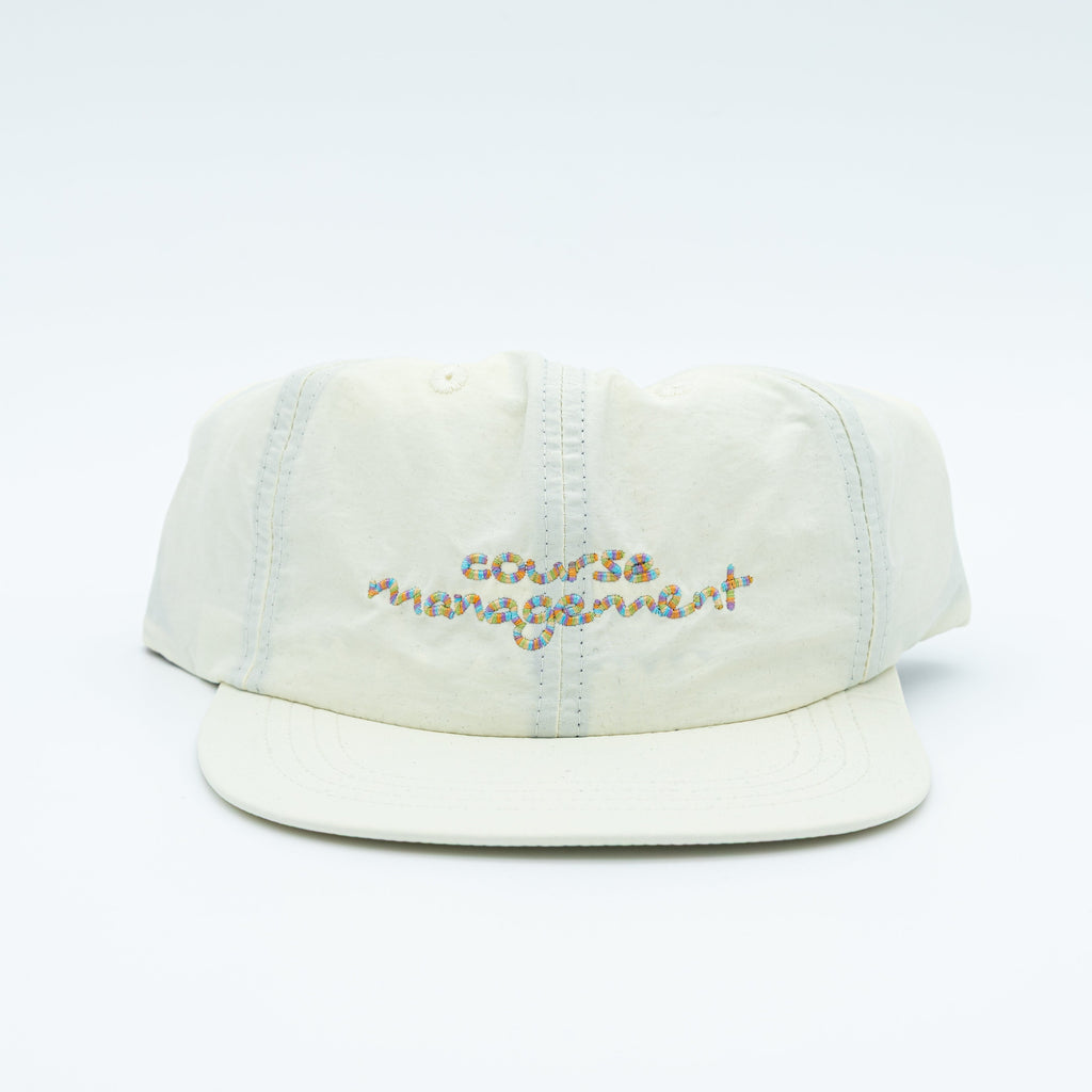 A light cream-colored cotton cap with 'course management' embroidered in multicolor thread on the front, set against a plain white background.