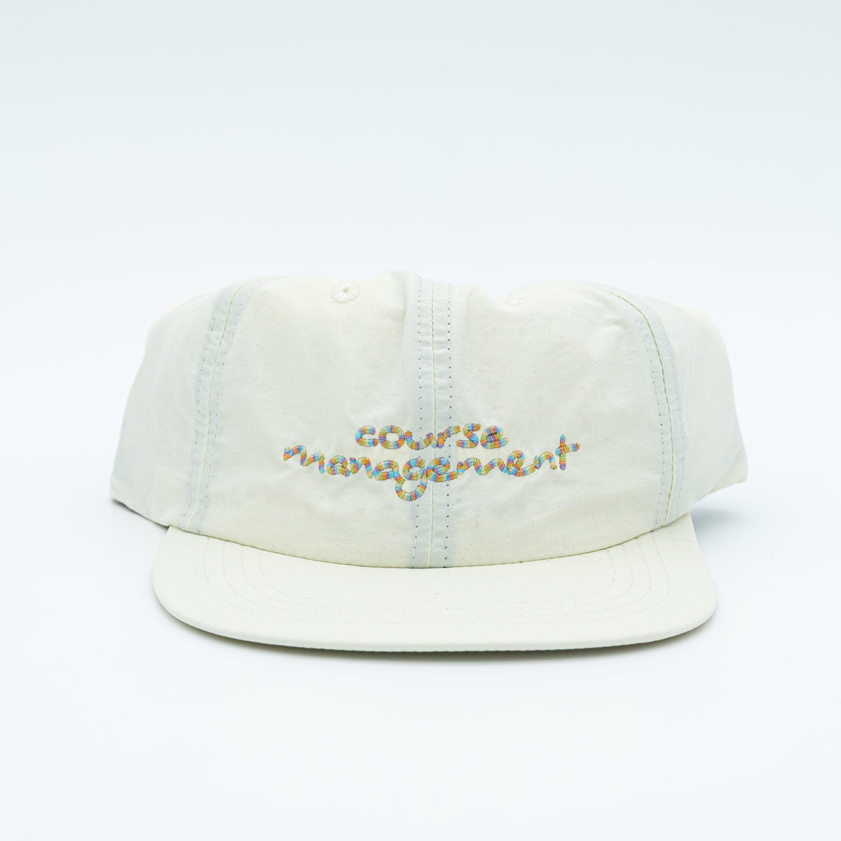 A light cream-colored cotton cap with 'course management' embroidered in multicolor thread on the front, set against a plain white background.
