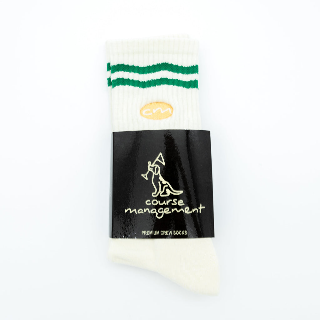 A single white crew sock with two green stripes near the cuff and a black paper band labeled 'course management' and 'PREMIUM CREW SOCKS', photographed on a plain white background.