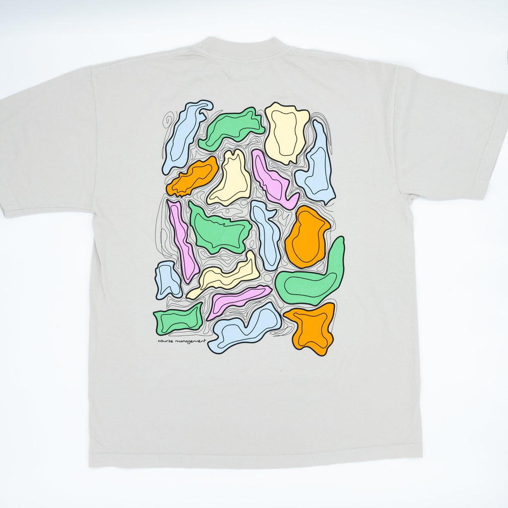 A light beige t-shirt shown flat against a white background, featuring a large graphic print on the back with abstract wavy shapes.