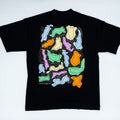 A black short-sleeve t-shirt laid flat on a light background, showing a large colorful abstract graphic print on the back. 
