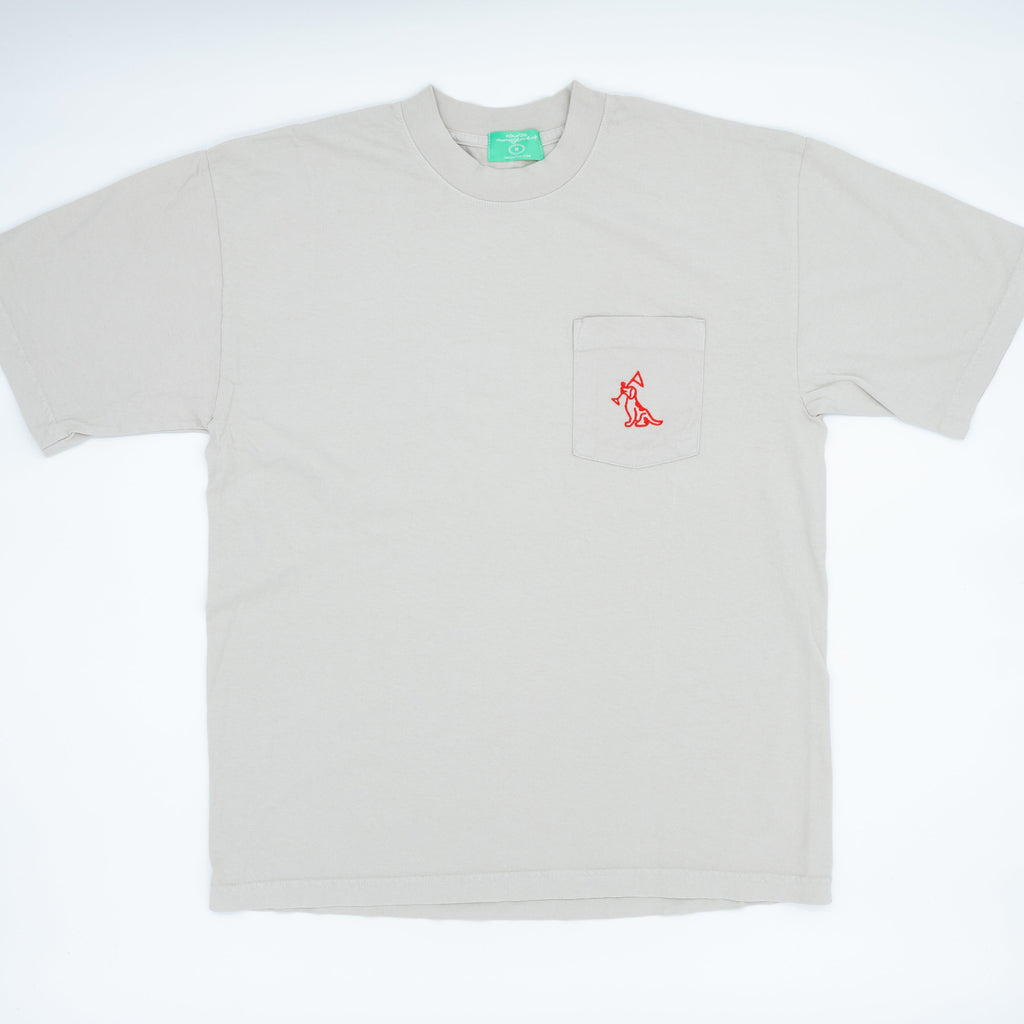 A light beige short-sleeve pocket t-shirt with a small red embroidered logo on the chest pocket, displayed flat against a white background.