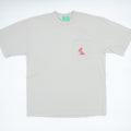 A light beige short-sleeve pocket t-shirt with a small red embroidered logo on the chest pocket, displayed flat against a white background.