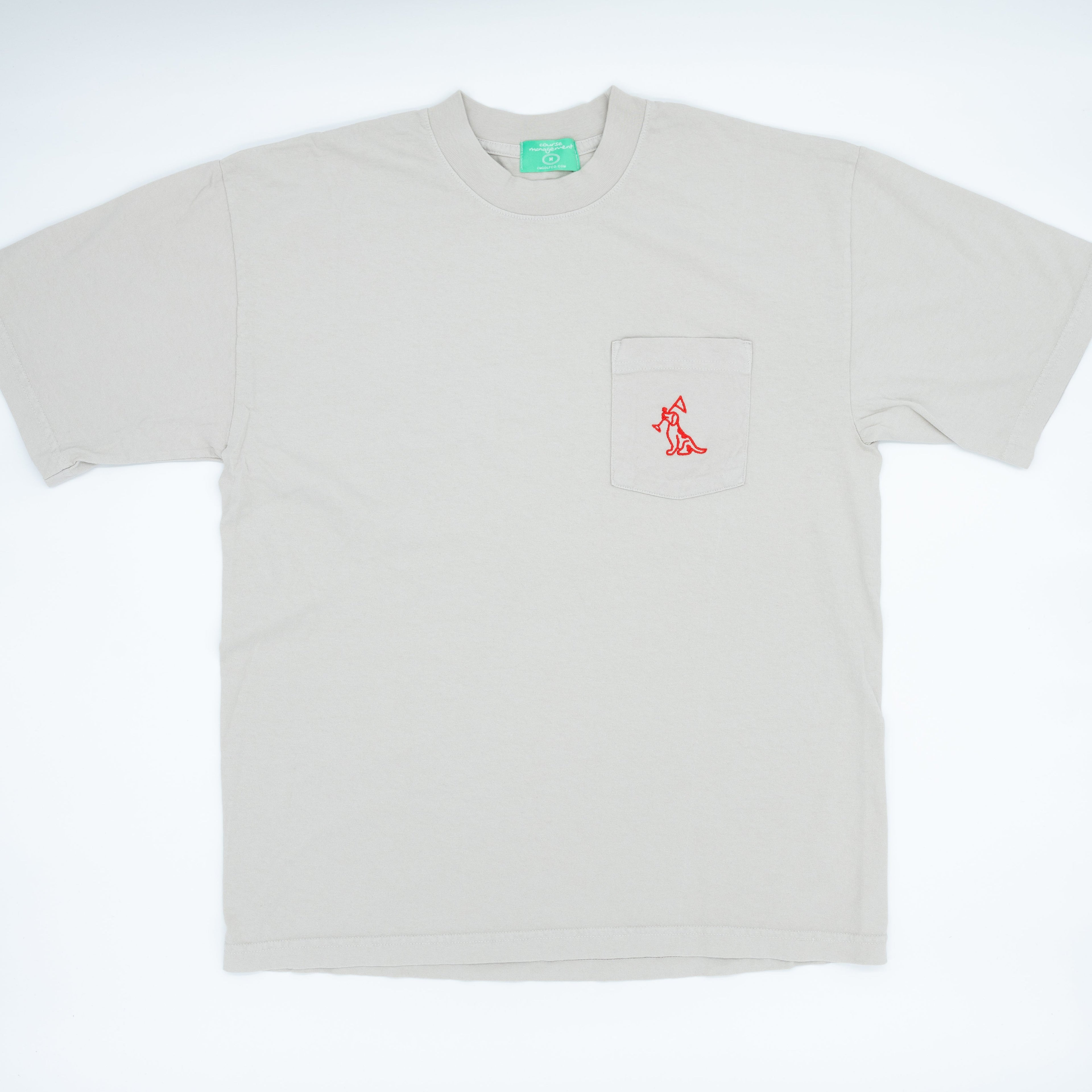 A light beige short-sleeve pocket t-shirt with a small red embroidered logo on the chest pocket, displayed flat against a white background.