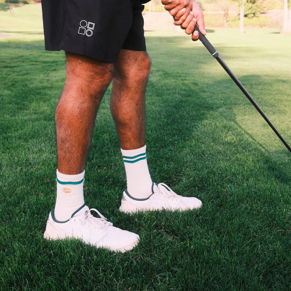 Man standing holding golf club.