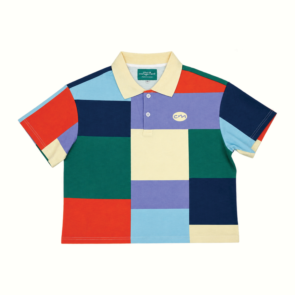 A short-sleeve patchwork polo shirt,  featuring a colorful geometric block pattern in navy, green, purple, light blue, red, and cream, with a cream collar and a small embroidered logo on the chest.