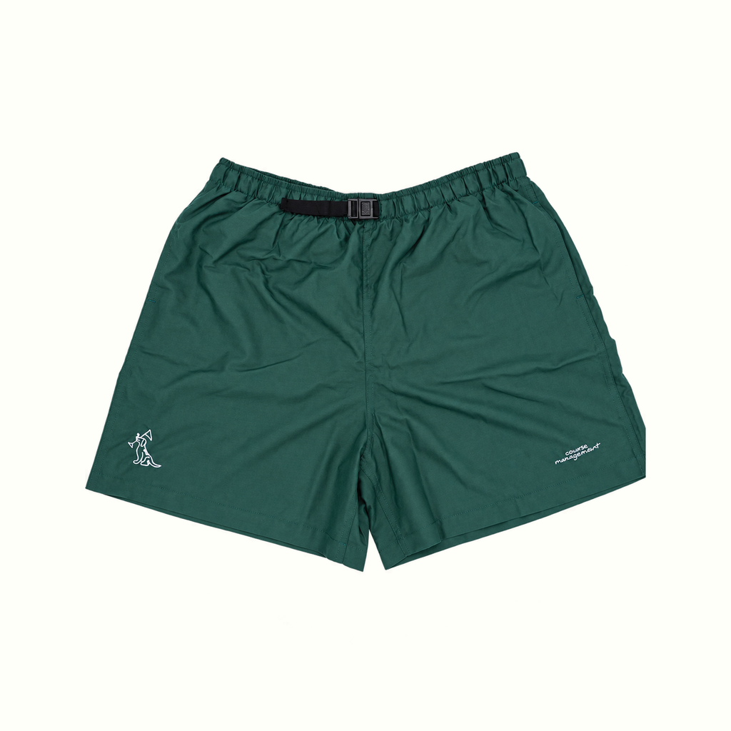 Dark green athletic shorts with an elastic waistband and a black belt, featuring a small white embroidered logo on each leg, displayed flat against a light off-white background.